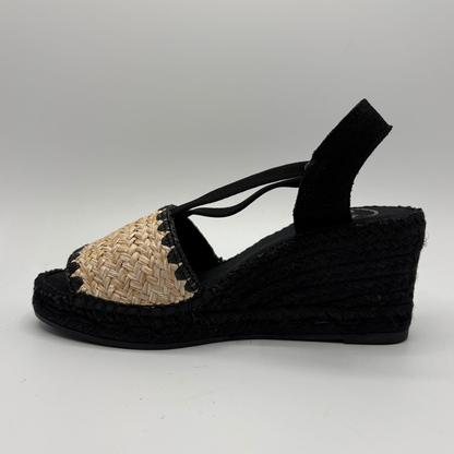 Black wedge sandal with straw sole on a white background