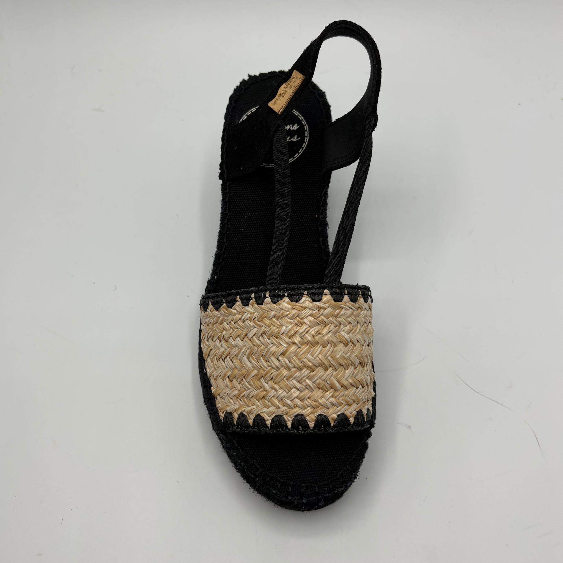 Black sandal with woven strap on a white background