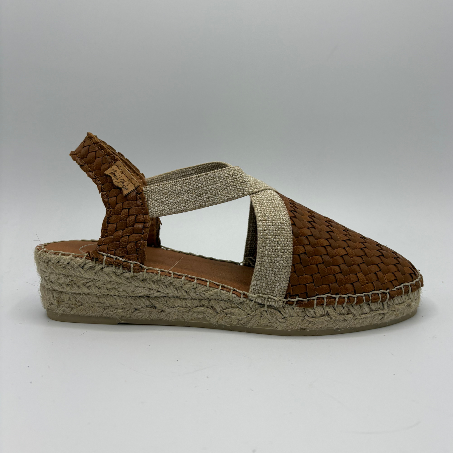 Brown woven sandal with a slingback strap on a white background