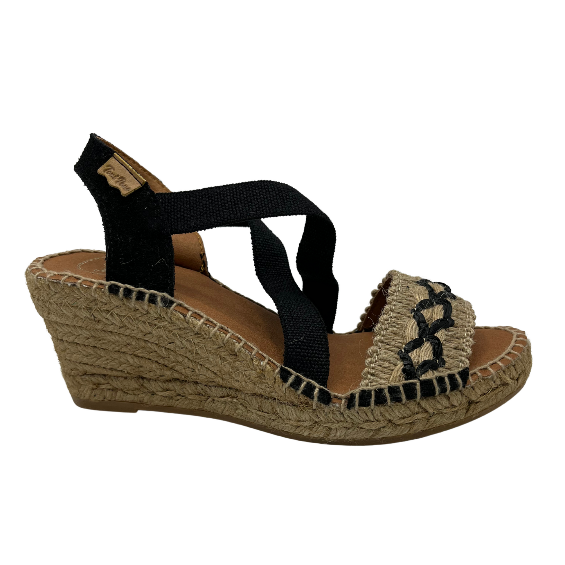 Right facing view of black and beige wedge sandal with X pattern across toe