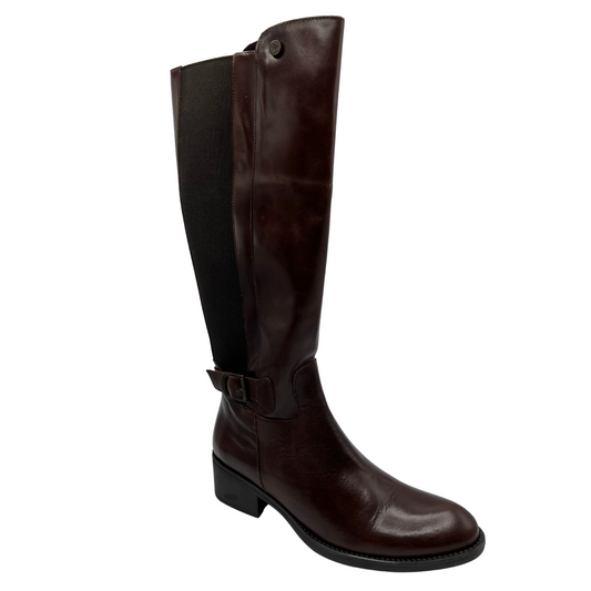 45 degree angled view of brown leather tall boots with elastic gore, short block heel and buckle detail