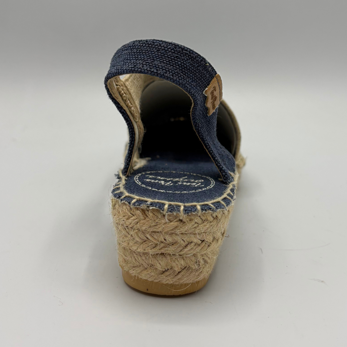 Navy wedge sandal with jute sole on a gray background