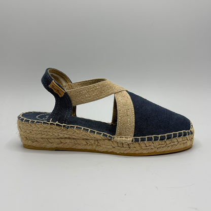Navy espadrille sandal with jute sole on a light gray background