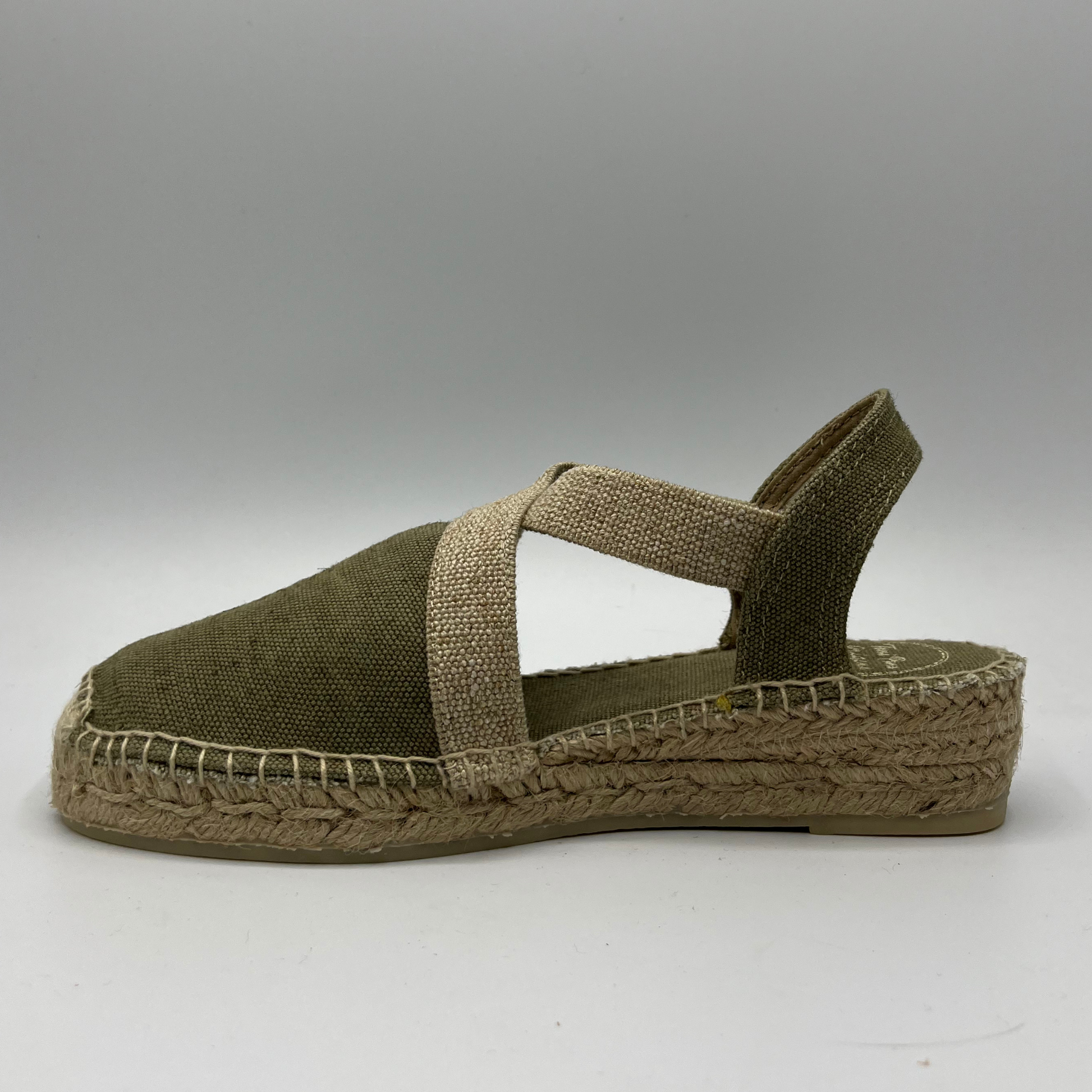 Left facing view of a canvas and textile espadrille with a low platform sole. 