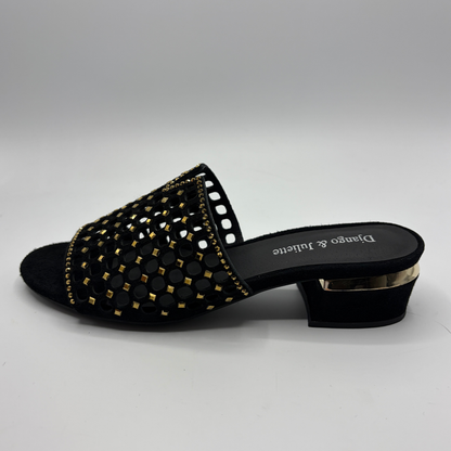Black sandal with gold detailing on a white background