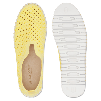 View of a pair of yellow slip on shoes with a white outsole