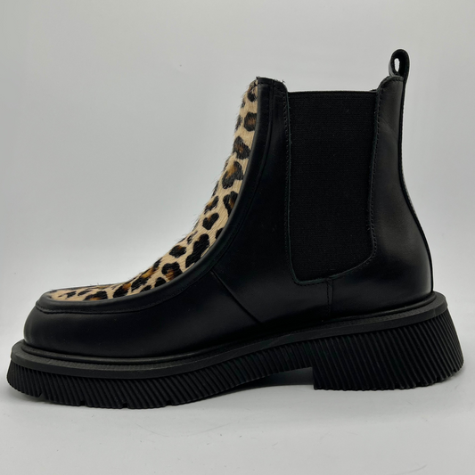 Black Chelsea boot with leopard print accent on a light gray background