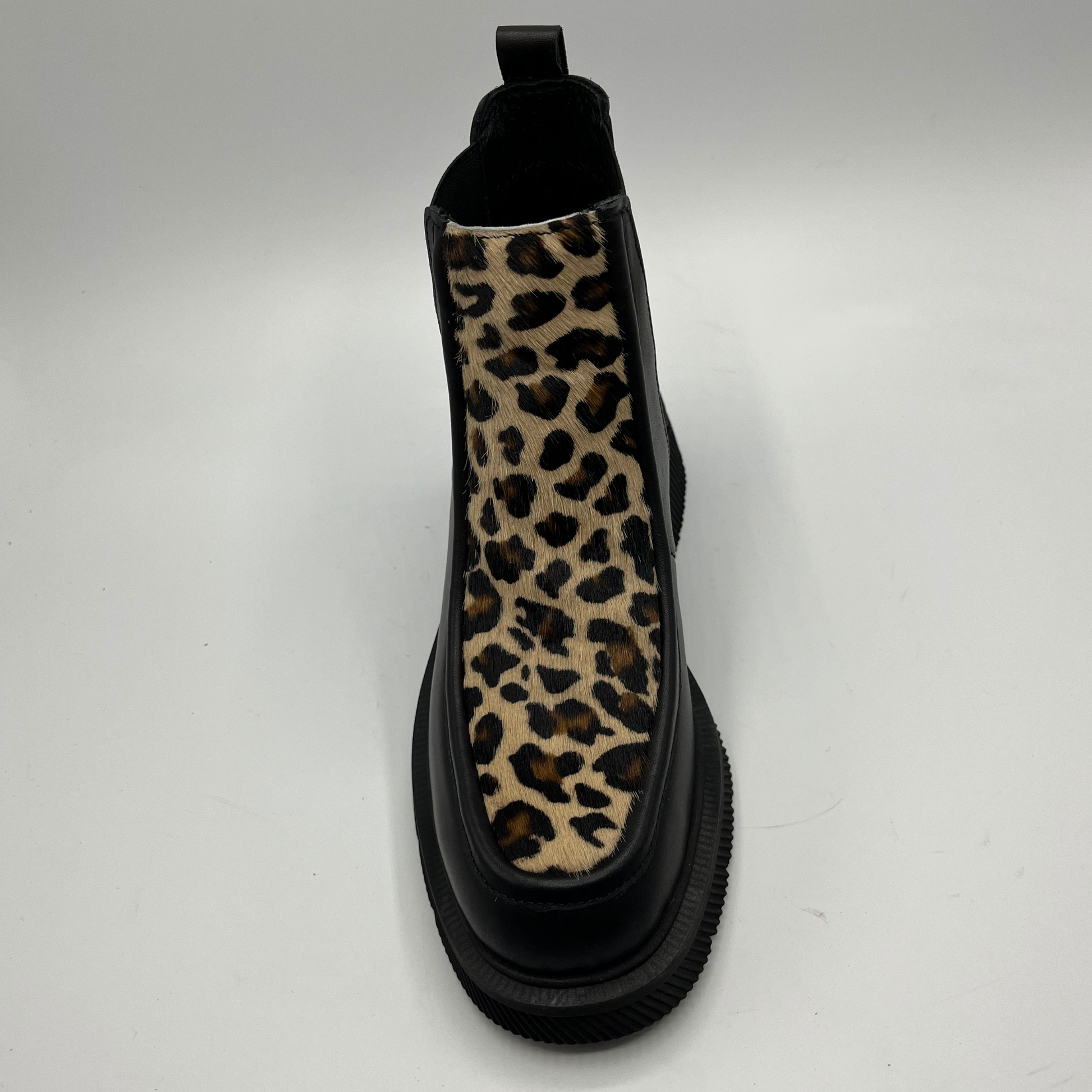 Black Chelsea boot with a leopard print accent on a white background