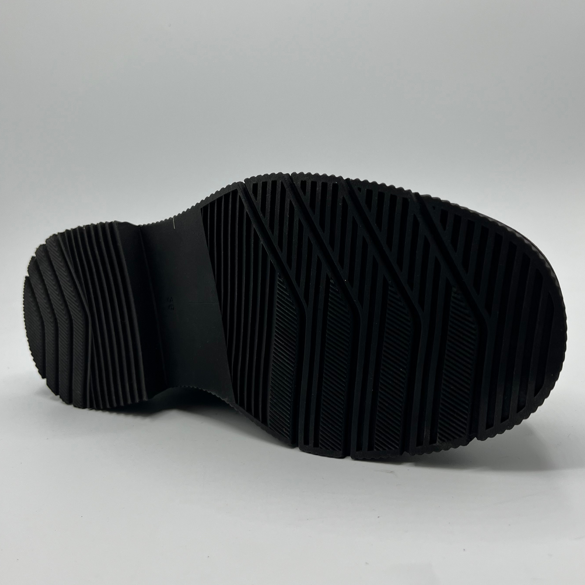 Black sole of a shoe on a light gray background