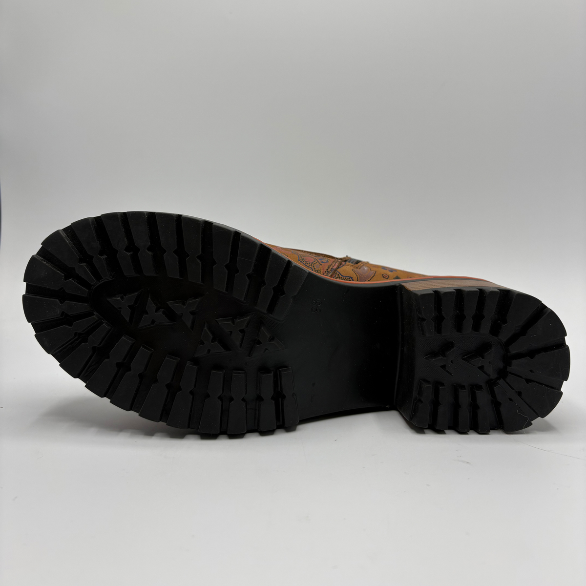 Bottom view of a tan boot with a floral motif, stacked heel and matching laces
