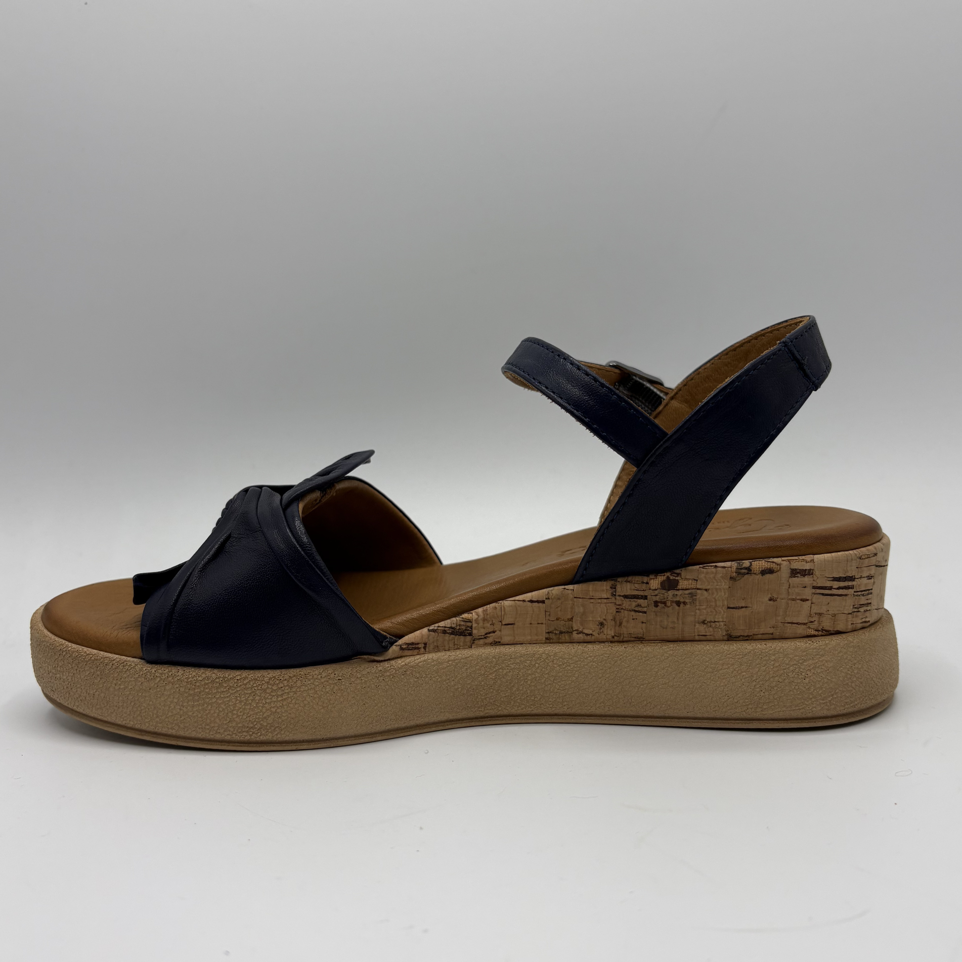 Dark navy sandal with a brown platform sole on a white background