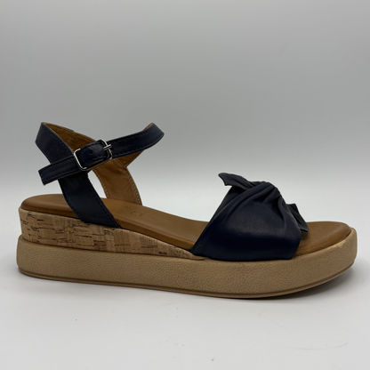 Dark navy sandal with a brown platform sole on a gray background