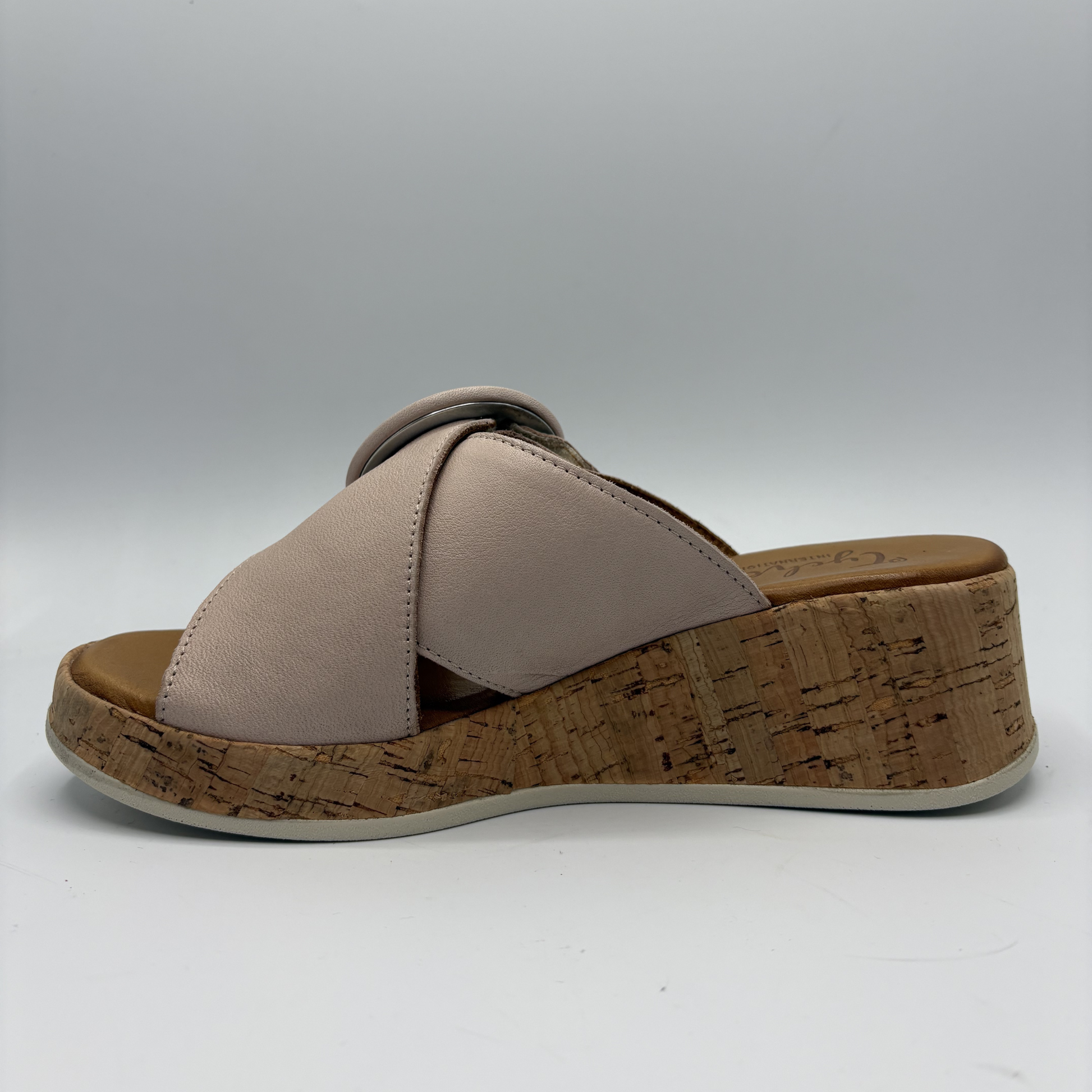Beige sandal with cork wedge sole on a white background
