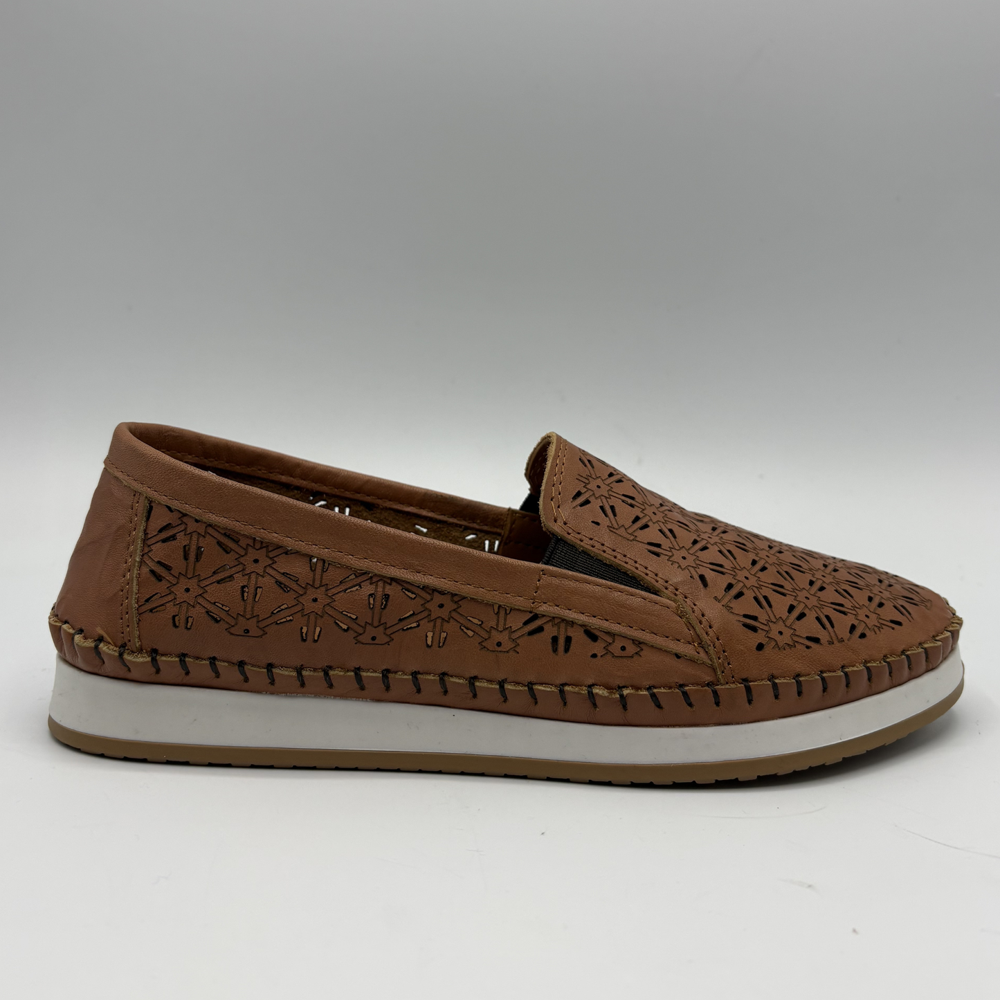 Right facing view of a brown leather slip on shoe with a white outsole