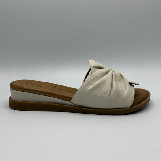 Beige sandal with a brown sole on a white background