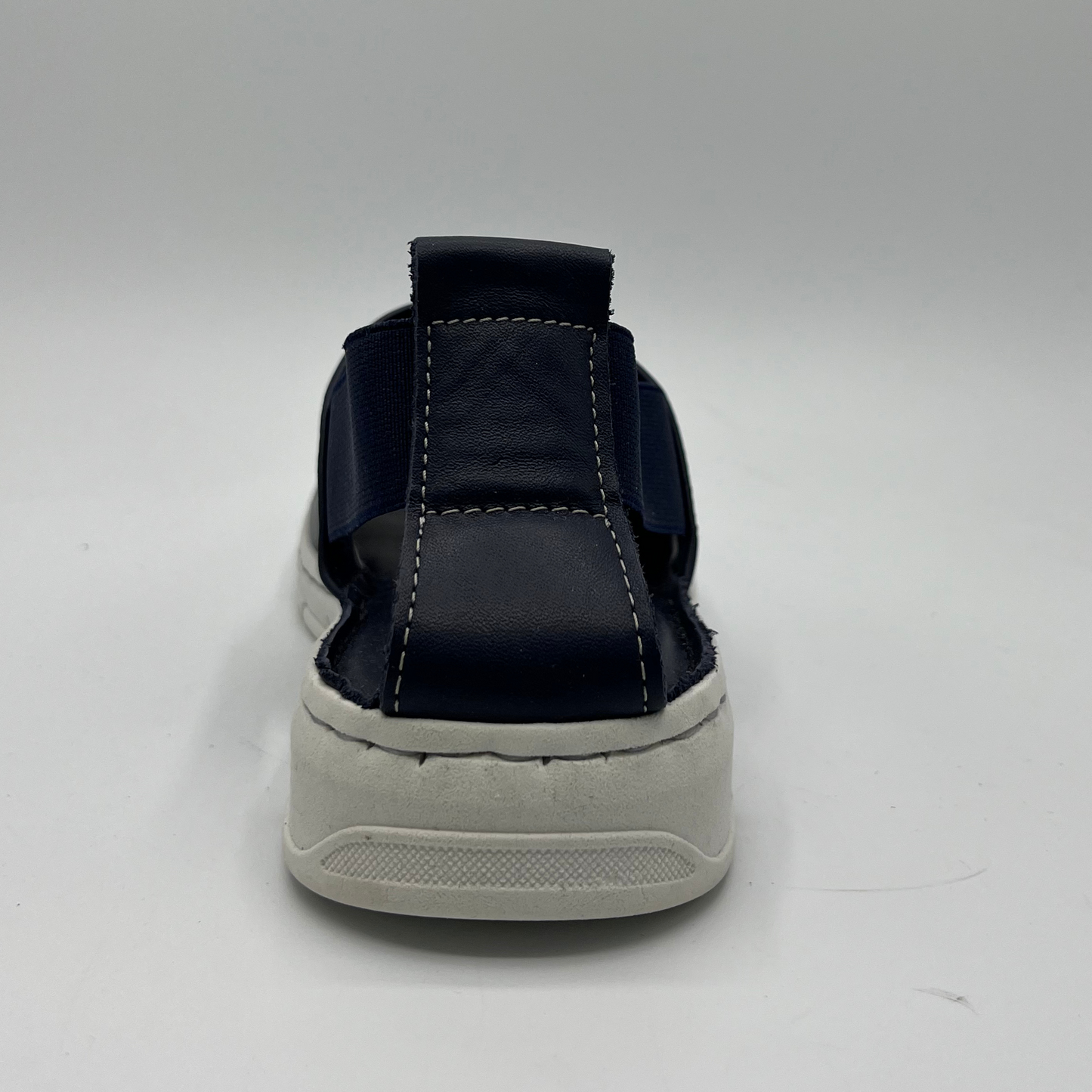 Back view of a slip on shoe with elasticated side bands, peep toe and a white rubber outsole.