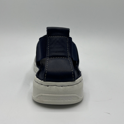 Back view of a slip on shoe with elasticated side bands, peep toe and a white rubber outsole.