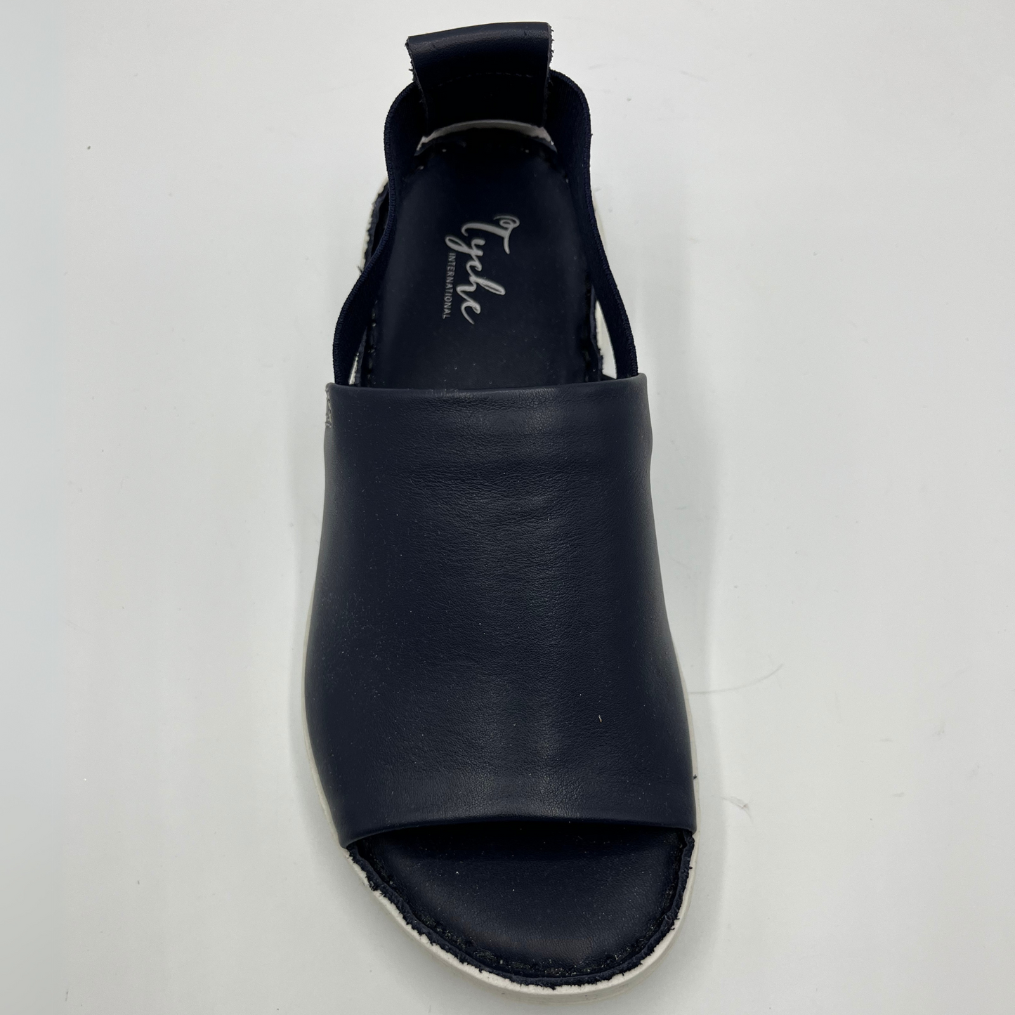 Top view of a slip on shoe with elasticated side bands, peep toe and a white rubber outsole.