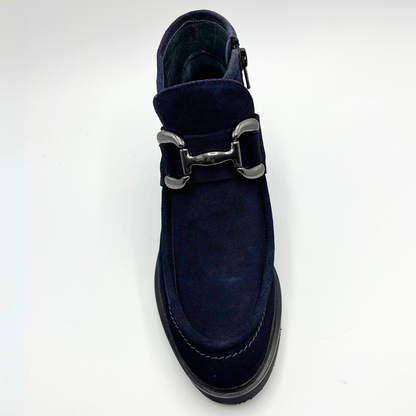 Navy blue shoe with a silver buckle on a white background