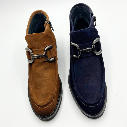Brown and navy suede shoes with metallic buckles on a white background