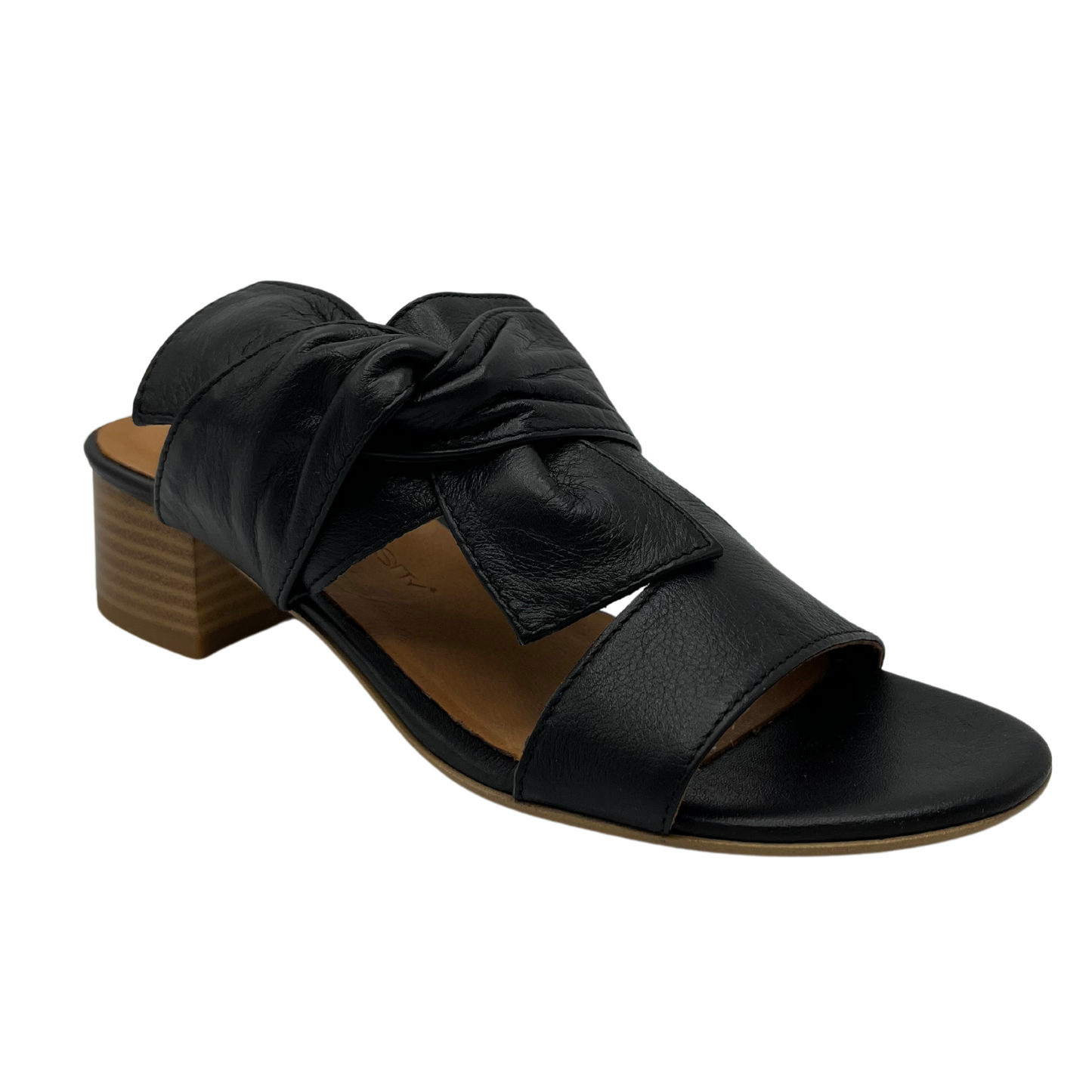 45 degree angled view of black leather sandal with block heel and knot detail. 