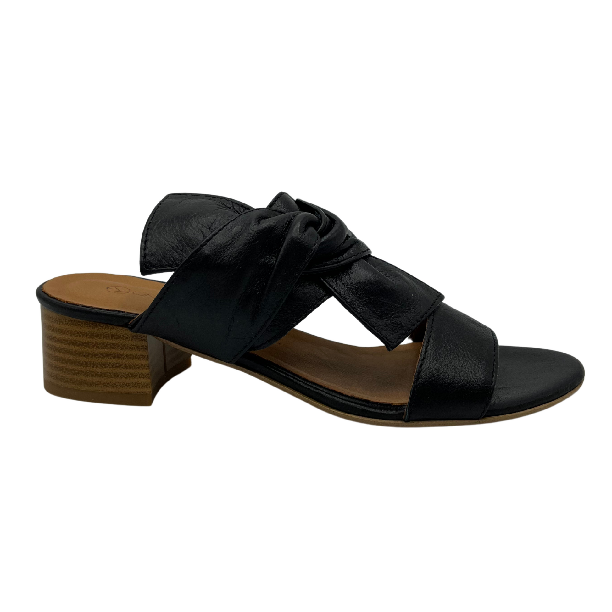 Right facing view of black leather sandal with block heel and knot detail.