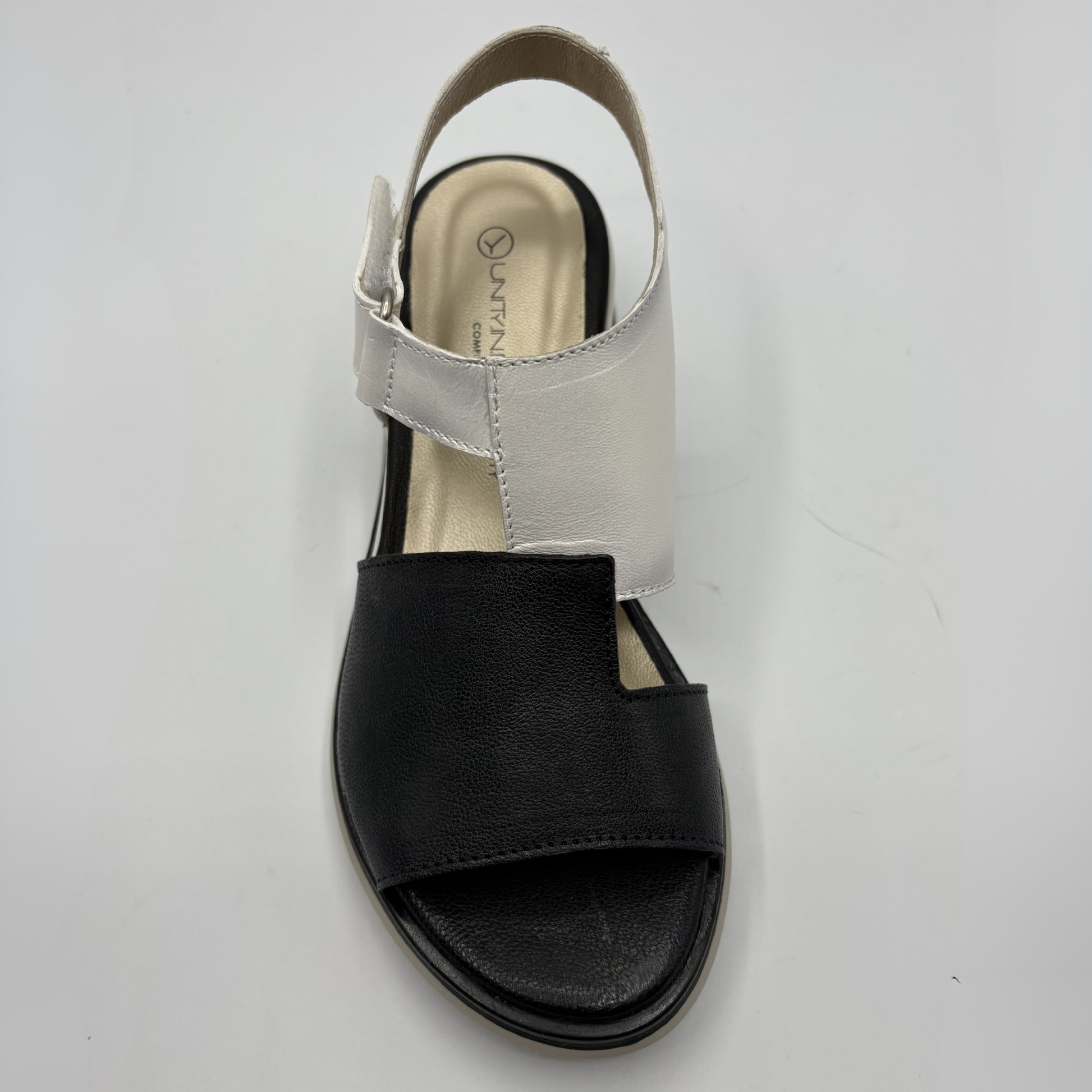 Black sandal with a white strap on a white background