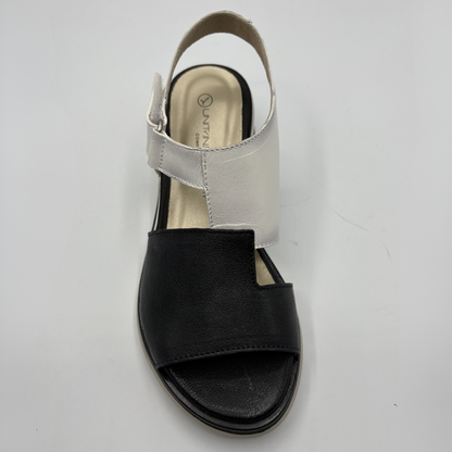 Black sandal with a white strap on a white background