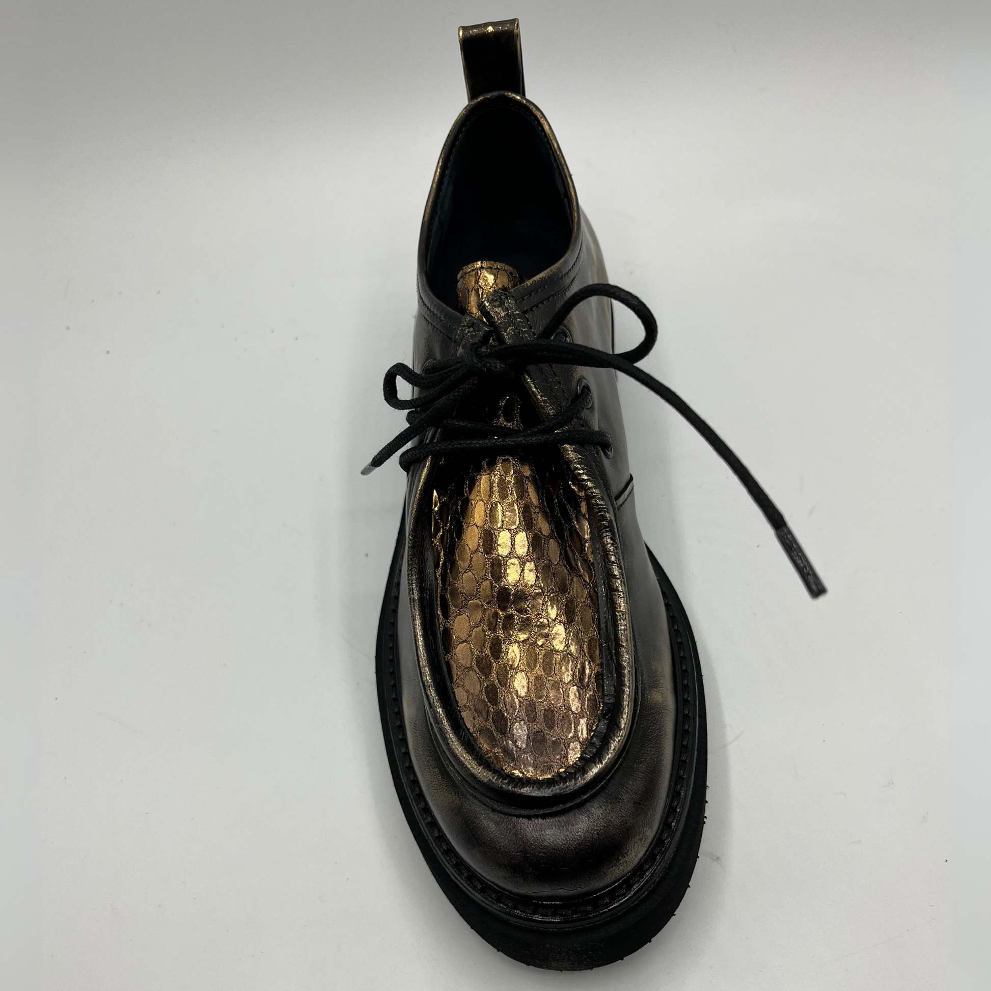 Gold leather shoe with gold interior on a white background