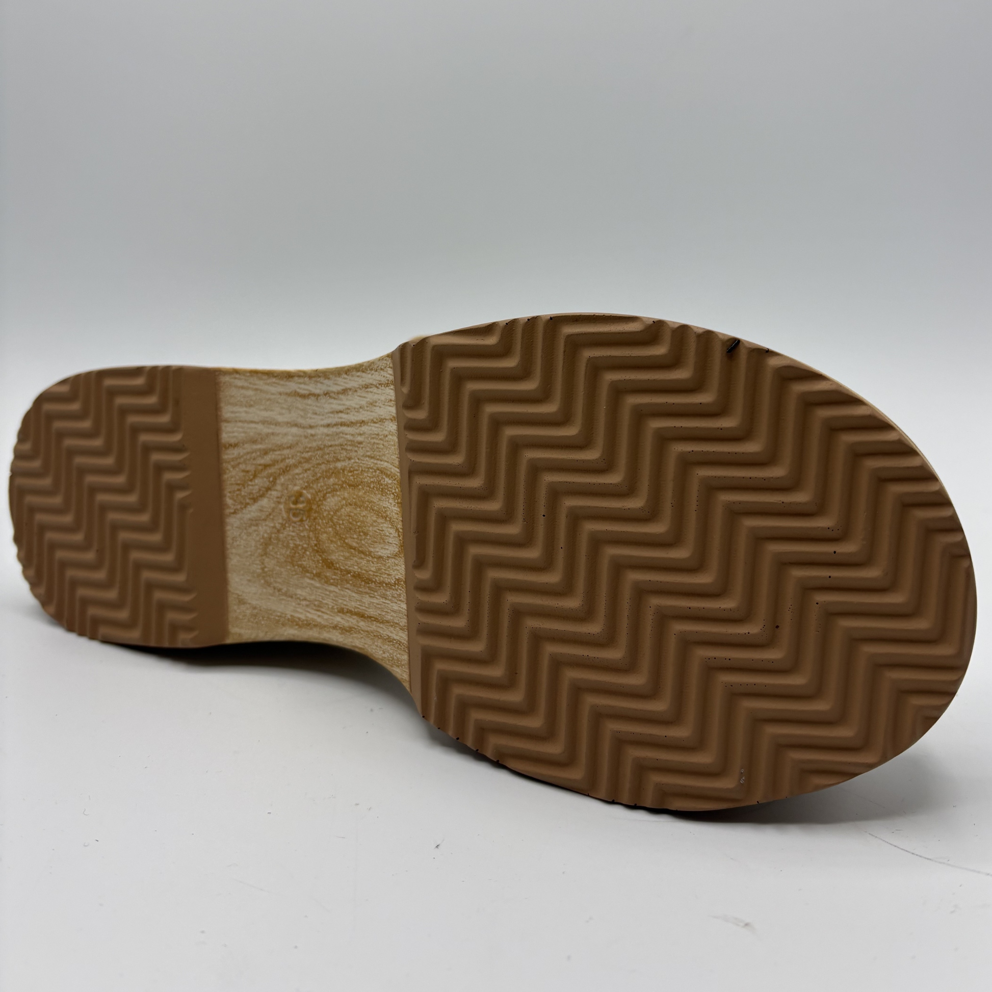 Brown zigzag patterned sole of a shoe on a white background