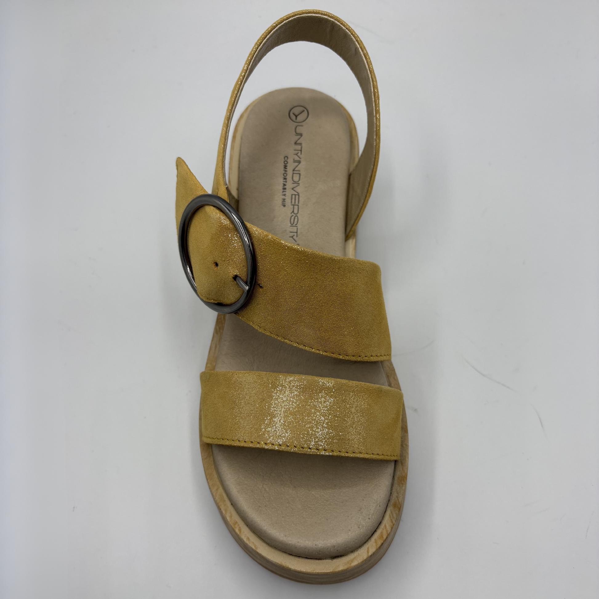 Yellow sandal with a black circular buckle on a white background