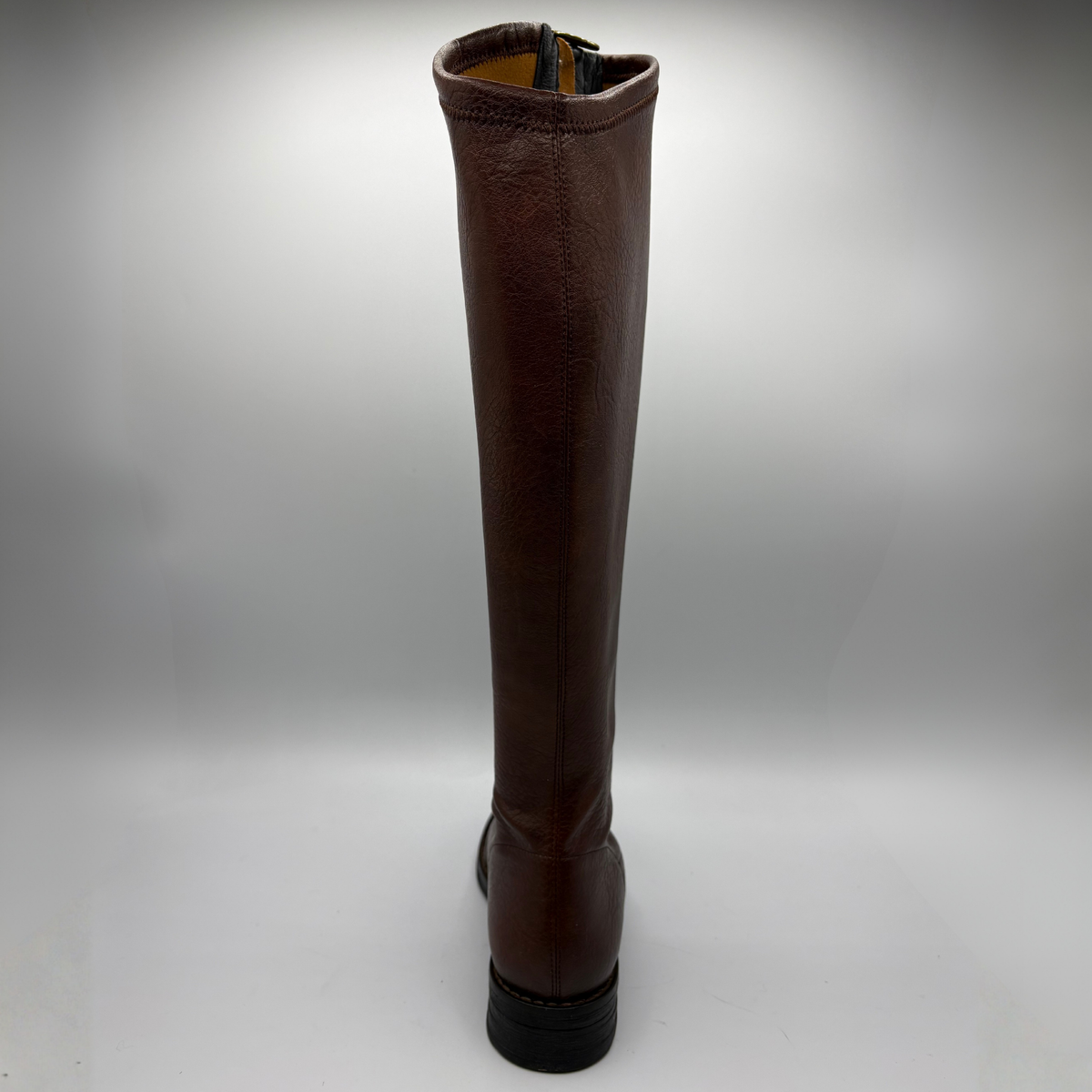 A single knee-high brown leather boot with a dark brown crocodile textured toe cap and a black sole, shown from the back  against a light gray background.