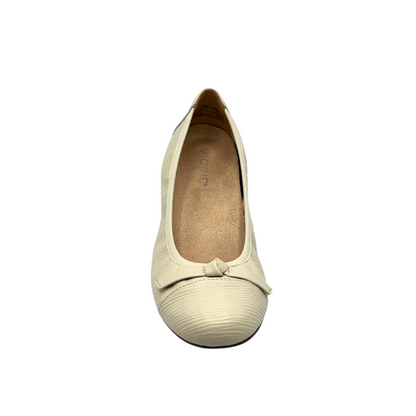 Top down view of a cream leather ballet flat.  Leather is textured