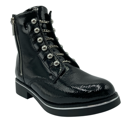 45 degree angled view of black patent leather boot with side zipper closure and pearl button detail along upper
