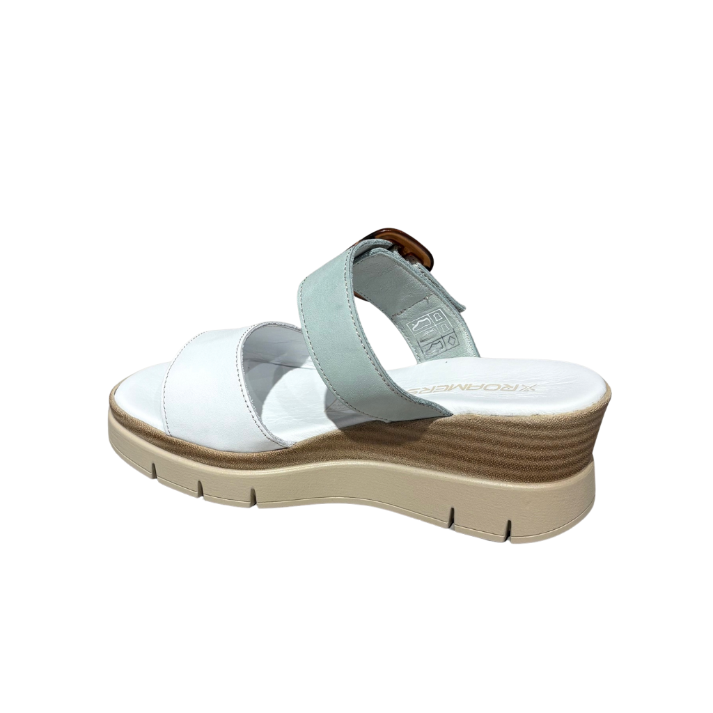 White sandal with a brown sole on a white background