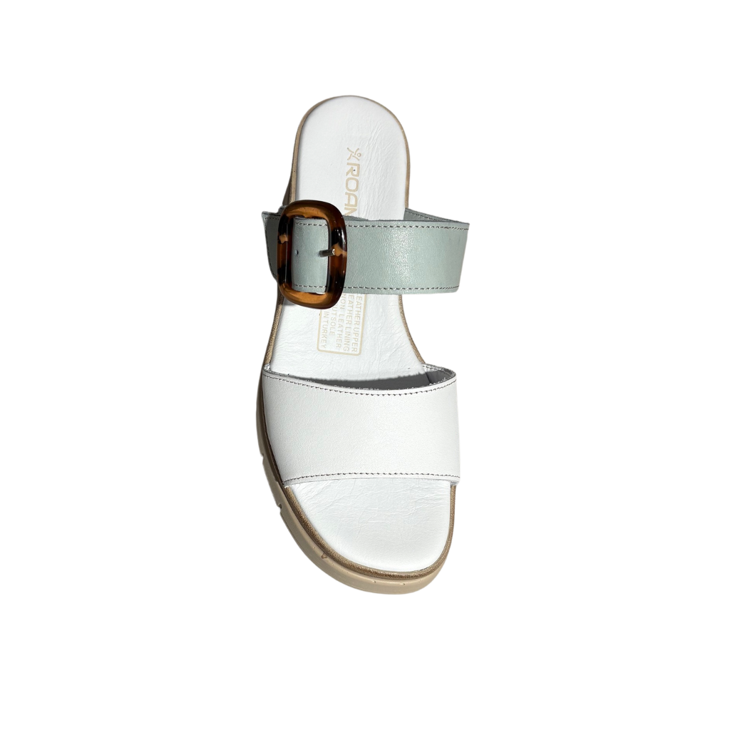 White sandal with a strap and tortoiseshell buckle on a white background
