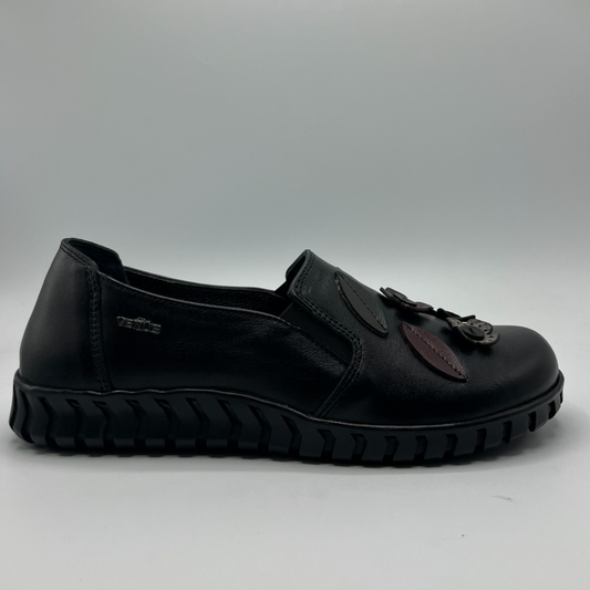 Black shoe with leather accents on a gray background