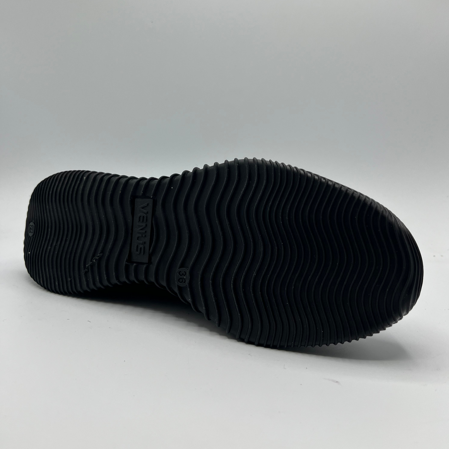 Black sole of a shoe on a gray background