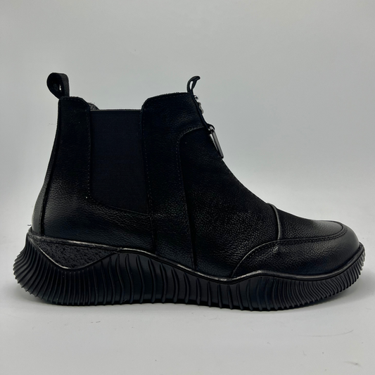 Black Chelsea boot on a gray background