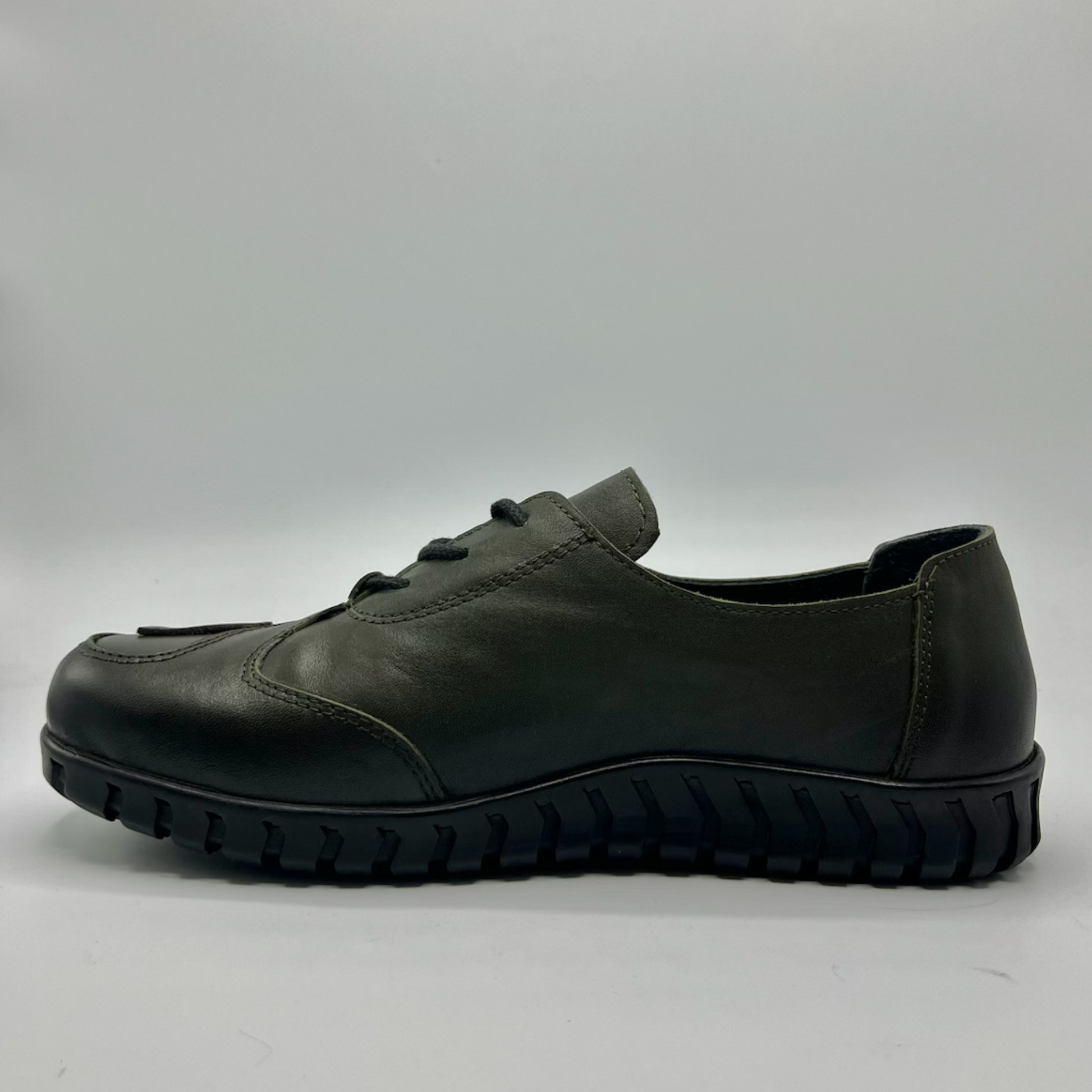 Green leather shoe on a gray background