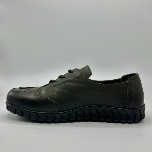 Green leather shoe on a gray background