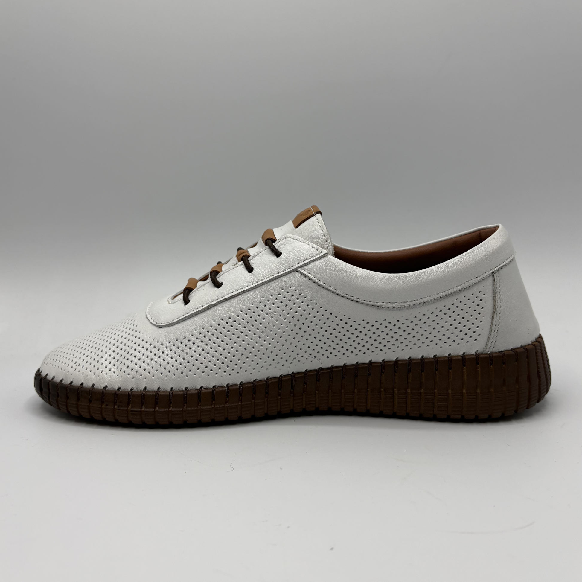 White shoe with brown sole on a gray background