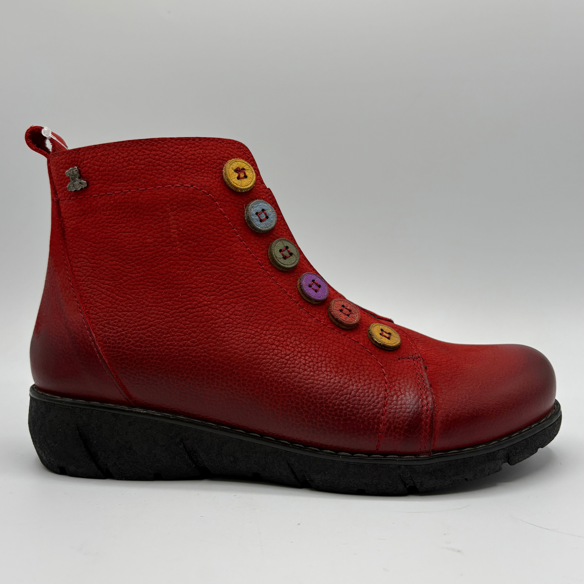 Right facing view of a red short boot with colourful buttons, a black outsole and a pull on heel tab