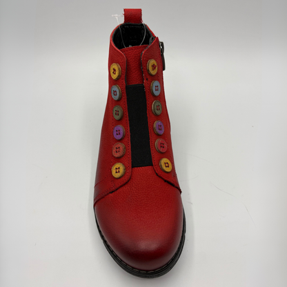 Top view of a red short boot with colourful buttons, a black outsole and a pull on heel tab