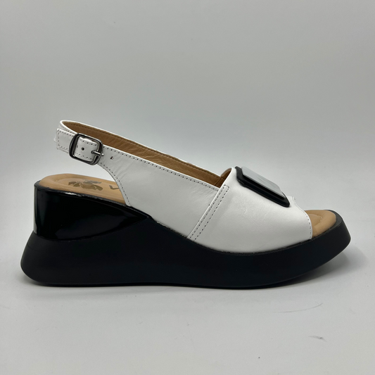 Right facing view of a white leather wedge sandal with an adjustable slingback strap and a contrasting black wedge heel.
