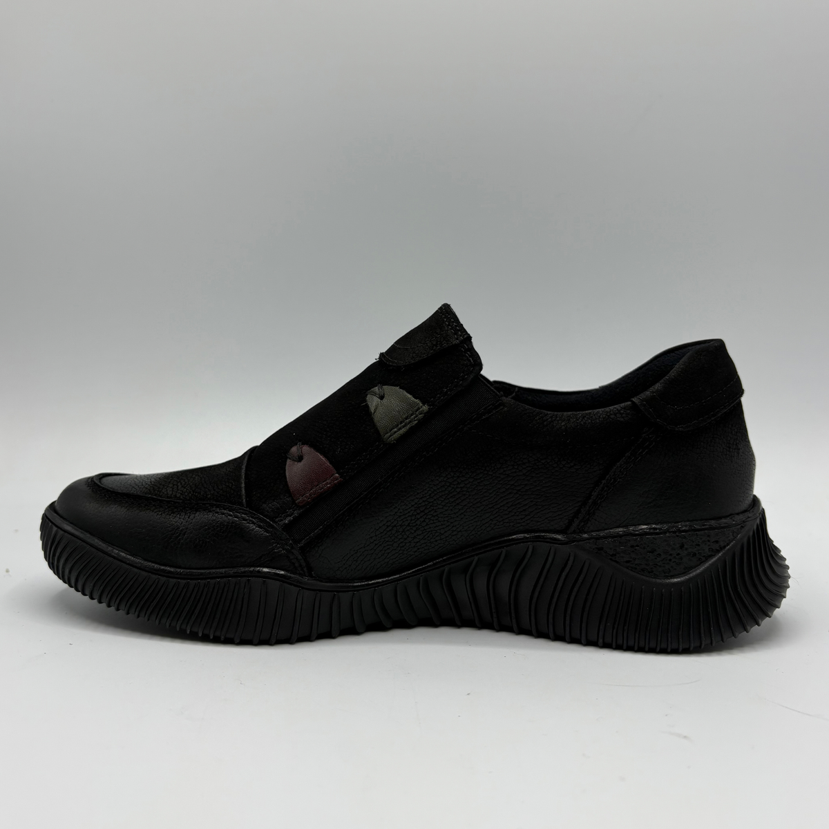 Left facing view of a black leather sneaker with a supportive outsole