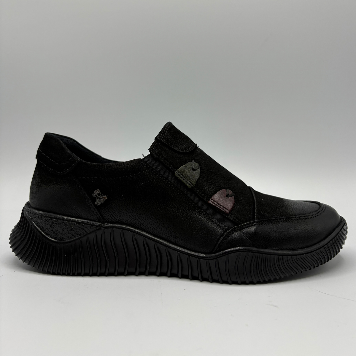 Right facing view of a black leather sneaker with a supportive outsole