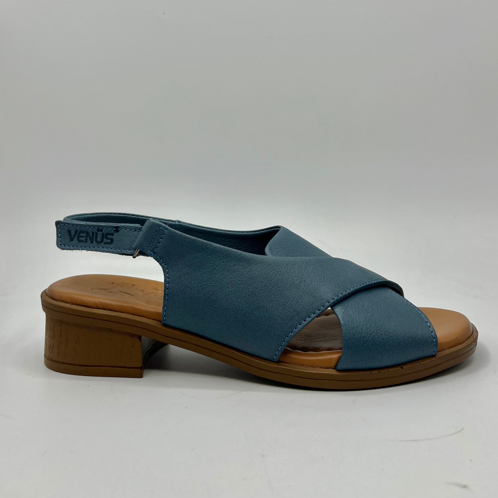 Right facing view of a blue cross strapped sandal with an adjustable slingback strap with a short heel.