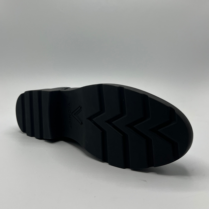 Bottom view of a black leather ankle boot.
