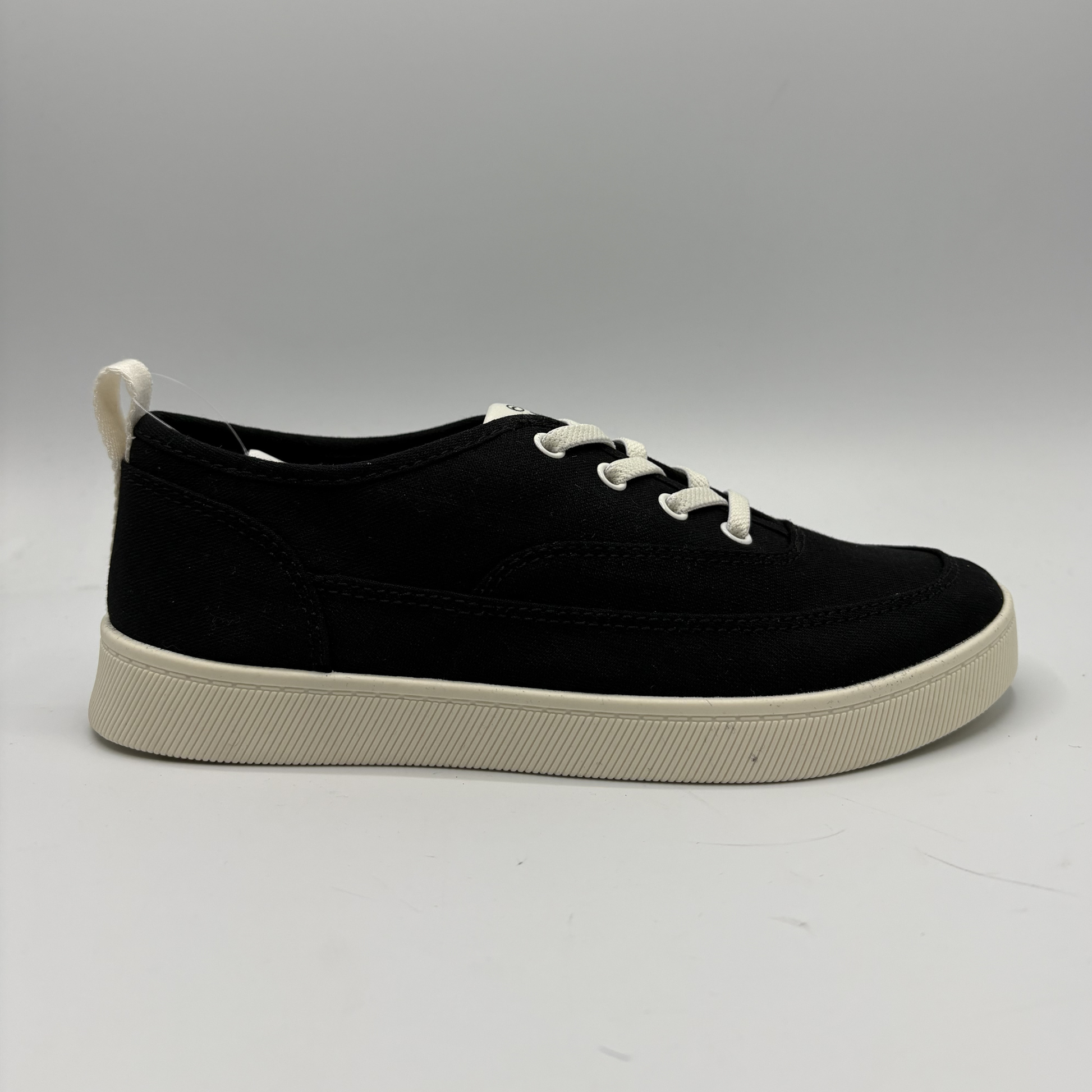 Right facing view of a black sneaker with a white outsole.